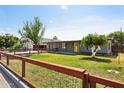 Charming home exterior featuring a well-kept lawn and a welcoming yellow front door at 6814 N 14Th St, Phoenix, AZ 85014