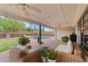 Relaxing covered patio with wicker furniture, ceiling fans, and views of the pool and backyard at 710 E Hayward Ave, Phoenix, AZ 85020