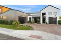 Exterior view with a modern black garage door and a green lawn at 1013 W Ardmore Rd, Phoenix, AZ 85041