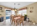 Bright dining area with tile floors, a table set for a meal, and a sliding glass door to the backyard at 10541 W Foothill Dr, Peoria, AZ 85383