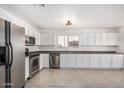 Spacious kitchen with stainless steel appliances, granite countertops, and white cabinetry at 11836 W Rosewood Dr, El Mirage, AZ 85335