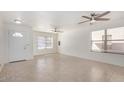 Bright living room with tiled floors, ceiling fans, and large windows offering plenty of natural light at 11836 W Rosewood Dr, El Mirage, AZ 85335