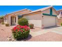 Single Gathering house featuring a two-car garage, front entrance, and manicured landscaping at 13824 N 148Th Ln, Surprise, AZ 85379