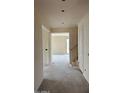 Hallway with white walls, a staircase with wood railings, and doorway that opens to a bright room at 15159 W Gray Fox Trl, Surprise, AZ 85387
