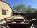 The backyard has a rectangular artificial turf, desert landscaping, and a fire pit with outdoor seating at 1526 E Hazel Dr, Phoenix, AZ 85042