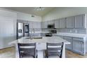 Modern kitchen with gray cabinets, stainless steel appliances, and a quartz island at 19808 N 3Rd Ave, Phoenix, AZ 85027