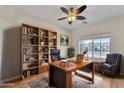 Cozy home office with custom bookcase, wooden desk and comfortable seating at 21759 E Estrella Rd, Queen Creek, AZ 85142
