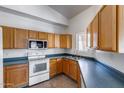 Well lit kitchen featuring wood cabinets, a stainless steel sink, and white oven and microwave at 22225 N 29Th Dr, Phoenix, AZ 85027