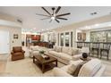 Spacious living room features wood floors, a ceiling fan, and an open layout to the kitchen and bar at 22233 N 54Th Way, Phoenix, AZ 85054