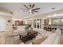 Open-concept living room featuring bright white furniture, a dark wood coffee table, and direct access to the kitchen and bar at 22233 N 54Th Way, Phoenix, AZ 85054