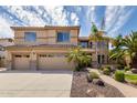 Charming two-story home showcasing a well-manicured front yard with lush landscaping and a three-car garage at 2302 S Canfield --, Mesa, AZ 85209