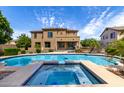 Backyard showcasing a sparkling pool and spa with a basketball hoop and covered patio of a two-story home at 2302 S Canfield --, Mesa, AZ 85209