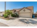 Spacious home featuring a large garage, desert landscaping, and a clear sky at 4207 W Soft Wind Dr, Glendale, AZ 85310
