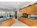 Bright kitchen featuring granite countertops, wood cabinetry, and views into the dining area at 4234 E Narrowleaf Dr, Gilbert, AZ 85298
