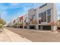 View of contemporary townhouses with attached garages and colorful trees lining the street at 4617 E Culver St, Phoenix, AZ 85008