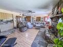 Spacious living room featuring a stone fireplace, wood-look floors, and comfortable seating at 4621 E Desert Forest Trl, Cave Creek, AZ 85331