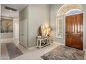 Entryway with a wooden front door, decorative table, mirror, rug and light tiled floor at 7492 E Buteo Dr, Scottsdale, AZ 85255