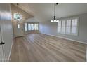 Bright living room showcasing light wood floors, plantation shutters, and stylish light fixtures at 8319 E Plata Ave, Mesa, AZ 85212
