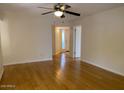 Bright living room featuring sleek, light-colored hardwood floors and a ceiling fan at 8702 N Shadow Ln, Peoria, AZ 85345