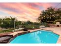Stunning pool with stone patio and fire pit overlooking picturesque views and the calm lake behind the property at 921 E Canyon Way, Chandler, AZ 85249