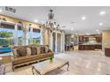 Spacious living room with stone floors, large windows, and sliding glass door to the backyard pool area at 921 E Canyon Way, Chandler, AZ 85249