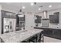 Modern kitchen with dark cabinets, stainless steel appliances, a large island, and pendant lighting at 10029 E Wavelength Ave, Mesa, AZ 85212