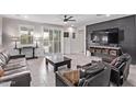 Stylish living room featuring tile floors, a ceiling fan, and an entertainment center on an accent wall at 10029 E Wavelength Ave, Mesa, AZ 85212