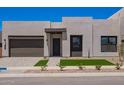 Contemporary home with a two-car garage, desert landscaping, and a clean, modern facade at 10332 E Utah Ave, Mesa, AZ 85212
