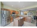 Bright kitchen with stainless steel appliances, wooden cabinets, an island, and tile flooring with an open design concept at 11156 E Lost Canyon Ct, Gold Canyon, AZ 85118