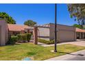 View of front of home with lush green landscaping and architectural details at 129 Leisure World --, Mesa, AZ 85206