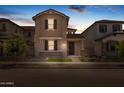 Dusk shot of charming two-story home with neutral stucco, landscaped front yard and covered entrance at 13473 N 158Th Ave, Surprise, AZ 85379