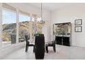 Elegant dining room with a glass table, modern light fixture, and stunning outdoor views at 15045 E Sundown Dr, Fountain Hills, AZ 85268