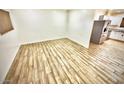 Open-concept living room featuring beautiful wood-look tile and lots of natural light, seamlessly flowing into the kitchen at 1546 W Pierce St, Phoenix, AZ 85007