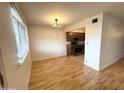 Open dining area next to kitchen with hardwood floors and stylish light fixture at 1702 W Tuckey Ln # 209, Phoenix, AZ 85015