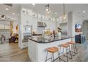 Bright kitchen features a large island, stainless steel appliances, and sleek white cabinets with bar stool seating at 19420 W San Juan Ave, Litchfield Park, AZ 85340