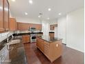 Spacious kitchen featuring an island, stainless steel appliances, granite counters, and wood floors at 19432 W Morning Glory Dr, Buckeye, AZ 85326