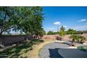 Lush backyard with mature trees, a stone-accented pool and spa, and a paved patio at 1970 E Yellowstone Pl, Chandler, AZ 85249
