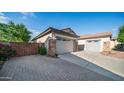 Long driveway leading to the garages, with a beautiful stone accent wall and desert landscaping at 1970 E Yellowstone Pl, Chandler, AZ 85249
