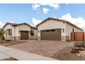 Beautiful home featuring a three-car garage, a brick driveway and stone accents at 24035 N 171St Dr, Surprise, AZ 85387
