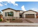 Charming single-story home with stone accents, a well-manicured yard, and a two-car garage at 24035 N 171St Dr, Surprise, AZ 85387