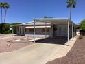 Inviting single-story home with awning-covered parking and thoughtfully designed front yard landscaping at 2405 N Eastwood Way, Mesa, AZ 85215