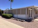 Single-story home featuring an enclosed porch area and low-maintenance rock landscaping at 2405 N Eastwood Way, Mesa, AZ 85215
