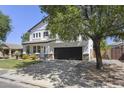Attractive two-story home with a dark garage door, lush lawn, and mature trees at 2562 E Los Alamos St, Gilbert, AZ 85295
