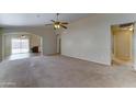 Large living space with neutral carpet, ceiling fan, and easy access to the outdoor patio at 25729 W St Charles Ct, Buckeye, AZ 85326