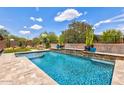 Backyard oasis featuring a sparkling pool with stone accents and lush desert landscaping at 2604 W Balao Dr, Phoenix, AZ 85085
