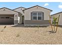 Charming single-story home featuring desert landscaping, a gray front door and shuttered window at 4035 S 176Th Dr, Goodyear, AZ 85338