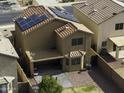 Aerial view of a two-story home with solar panels, a covered patio, and a landscaped backyard at 42006 W Hillman Dr, Maricopa, AZ 85138