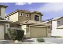Two-story house with a tile roof, two-car garage, and desert landscaping in front yard at 42006 W Hillman Dr, Maricopa, AZ 85138