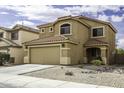 Two-story house with a tile roof, a two-car garage, and desert landscaping in front at 42006 W Hillman Dr, Maricopa, AZ 85138
