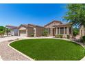 Charming home with manicured artificial lawn, xeriscaping, and stone accents at 4626 E Blue Spruce Ln, Gilbert, AZ 85298